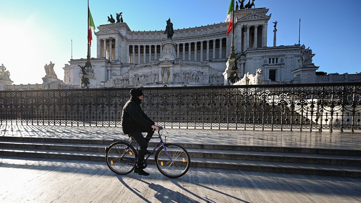 Un homme passe à vélo devant le monument Altare della Patria dans le centre de Rome, le 10 mars 2020. 