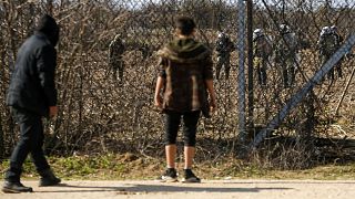 Migrants gather at a border fence on the Turkish side during clashes with the Greek riot police and army at the Turkish-Greek border in Pazarkule, Edirne region