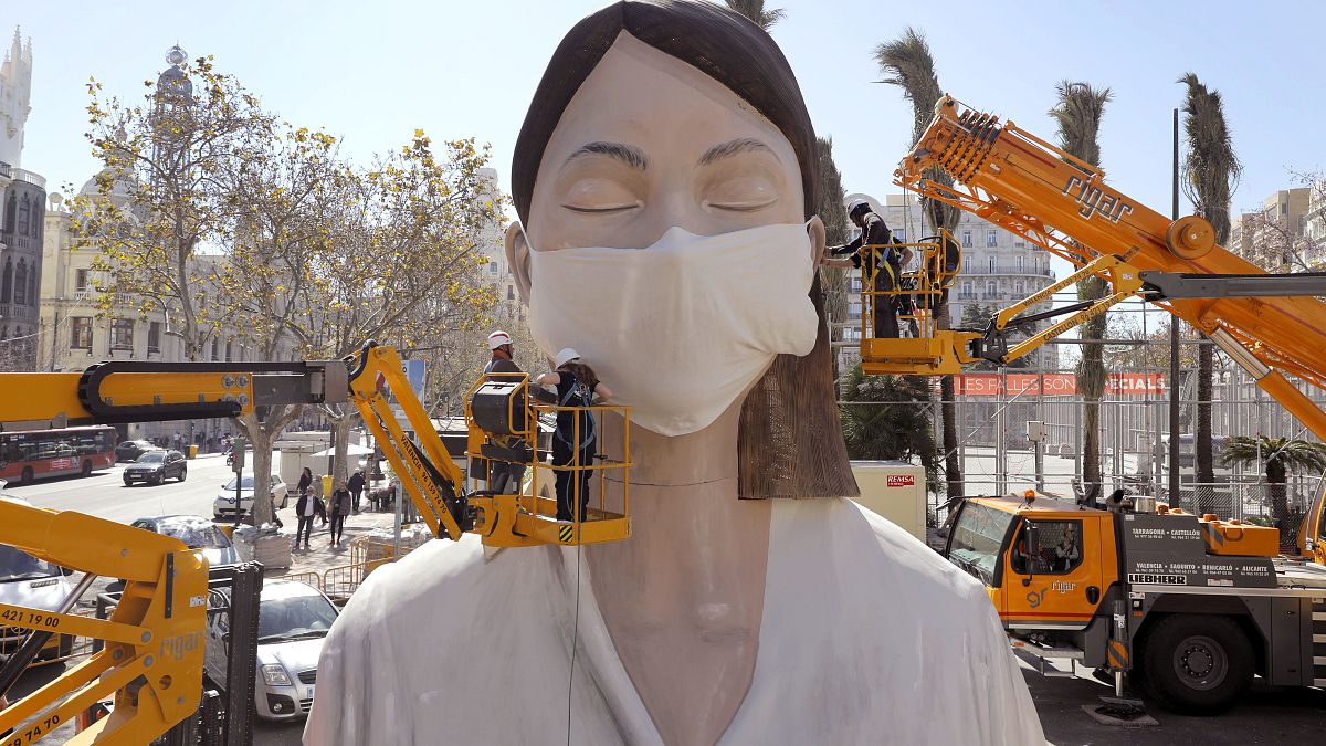 Рабочие приделывают маску на статую, приготовленную для фестиваля в Валенсии. Праздник отменили