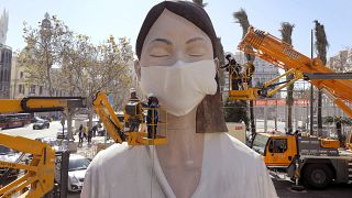 Рабочие приделывают маску на статую, приготовленную для фестиваля в Валенсии. Праздник отменили