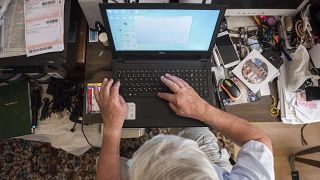 Otthonában laptopozik egy magyar férfi