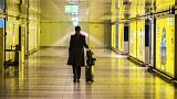 A woman walks with her suitcase down an empty corridor in the Rhine-Main Airport Thursday March 12, 2020.