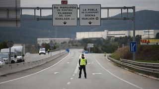 شرطي يغلق طريقا في اسبانيا مع فرض الحجر الصحي