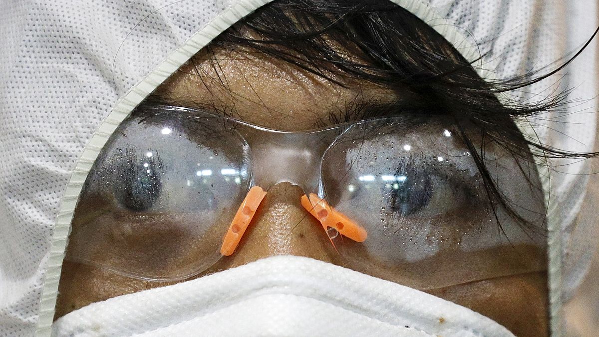 أحد العاملين في غوغل يلبس قناعا واقيا من فيروس كوفيد-19 في مدينة ماركينا في الفلبين. 13/03/2020