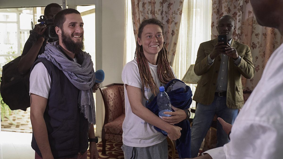 Italian Luca Tacchetto and Canadian Edith Blais are greeted by officials as they arrive at the airport in Bamako on March 14, 2020, after their release by UN peacekeepers.