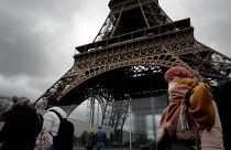 A woman wearing a mask walks pasts the Eiffel Tower closed after the French government banned all gatherings of over 100 people to limit the spread of virus COVID-19.