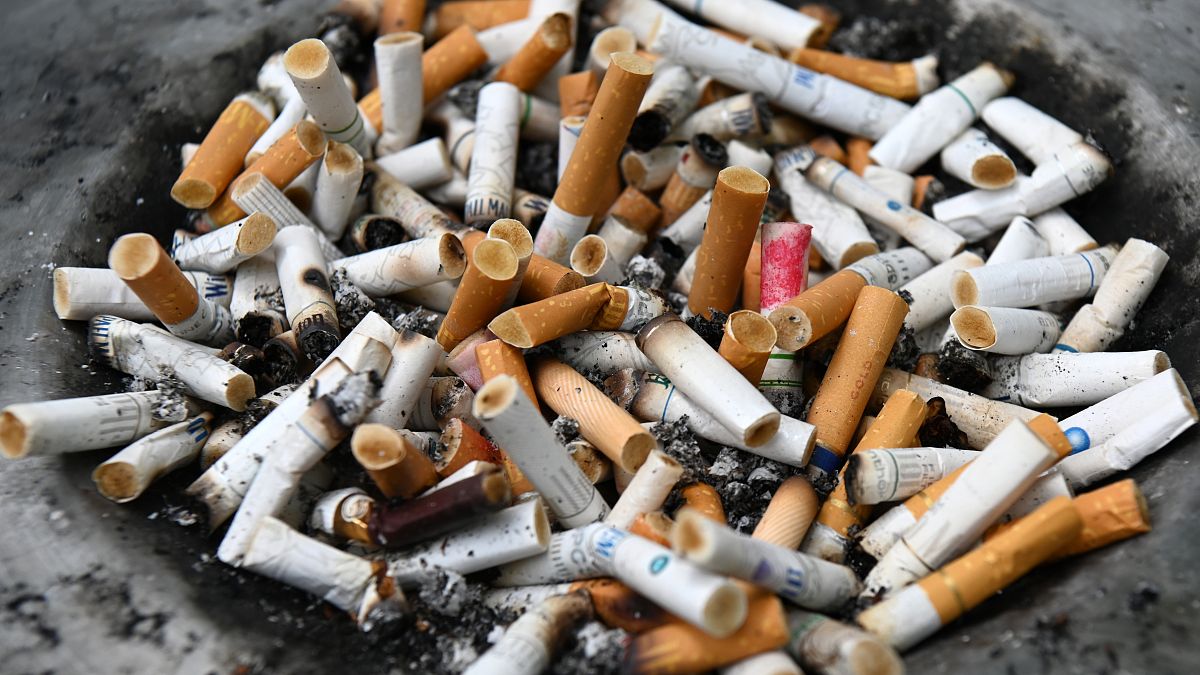 Cigarette butts are seen on a bin at a designated smoking area in Singapore on July 17, 2019. (Photo by ROSLAN RAHMAN / AFP)