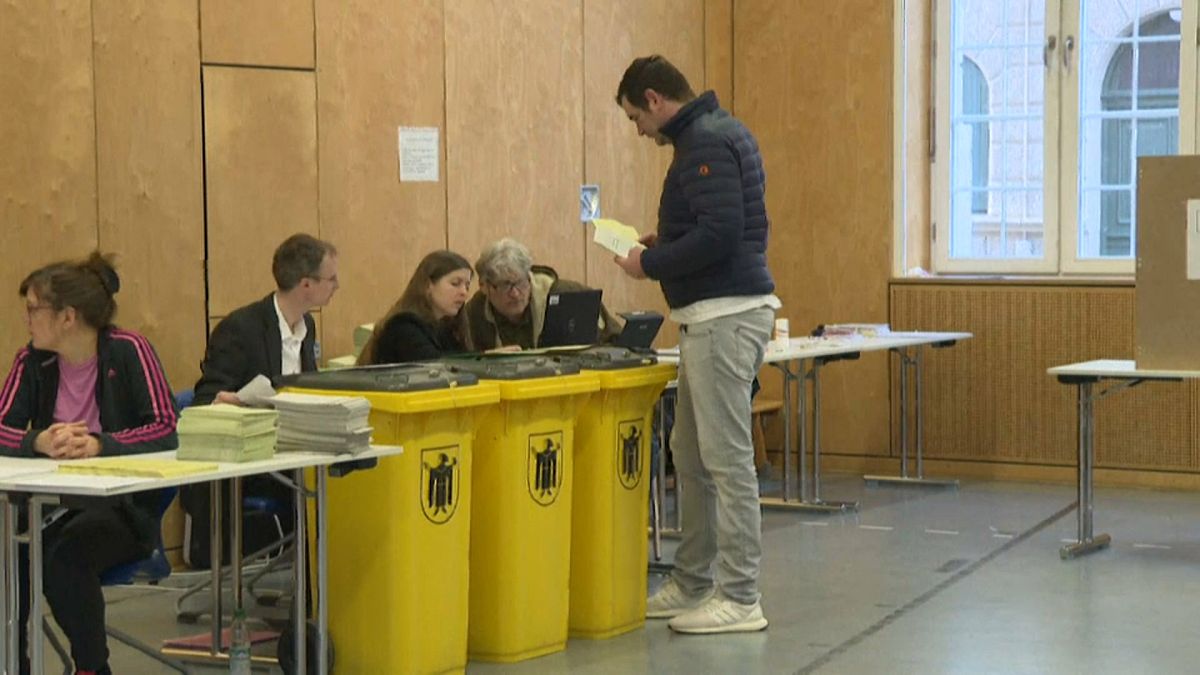 Election workers wearing protective gloves prepares the counting of the postal vote in an exhibition hall during municipal elections in Munich, southern Germany, on march 15, 