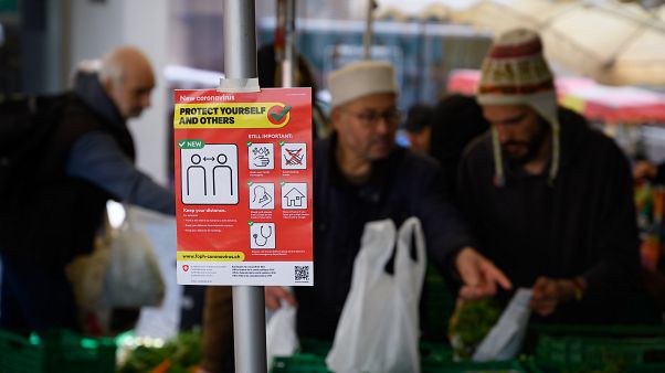 March 14, 2020 shows an information sign as eople are shopping in Saturday's market March 14, 2020 shows an information sign as eople are shopping in Saturday's market