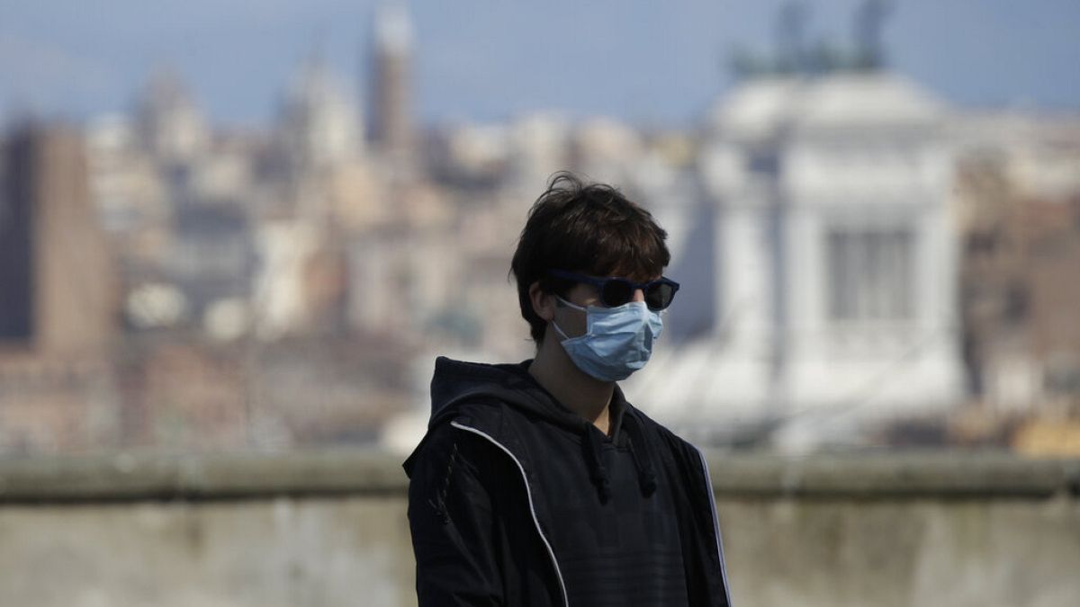 Un homme passe devant le Colisée à Rome en Italie le 15 mars 2020
