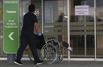 A hospital employment pushes a wheelchair into Nicosia General Hospital