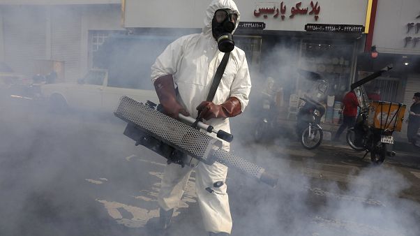 عامل من فرق الطوارئ يقوم برش مبيدات في شوارع العاصمة الإيرانية طهران عامل من فرق الطوارئ يقوم برش مبيدات في شوارع العاصمة الإيرانية طهران