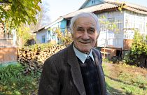 Ion Sandu, resident of old Cotul Mori, Moldova, stands in front of the house he refused to abandon