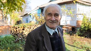 Ion Sandu, resident of old Cotul Mori, Moldova, stands in front of the house he refused to abandon 