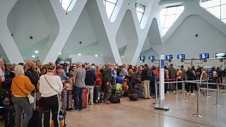 Passengers wait for their flights at the Marrakesh Airport on March 15, 2020