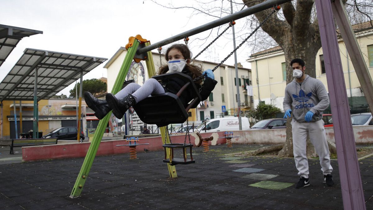 Un hombre y su hija jugando en un parque de la Roma en cuarentena