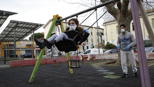 Un hombre y su hija jugando en un parque de la Roma en cuarentena Un hombre y su hija jugando en un parque de la Roma en cuarentena
