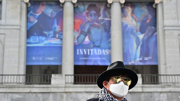 A South Korean tourists wearing a protective face mask walks in front of El Prado museum in Madrid on March 12, 2020 A South Korean tourists wearing a protective face mask walks in front of El Prado museum in Madrid on March 12, 2020