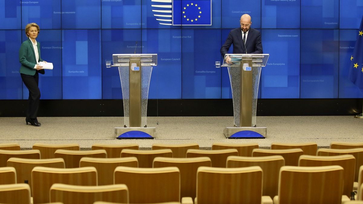 Charles Michel and Ursula von der Leyen arrive to address a nearly empty press theatre after a video-conference with G7 leaders at the European Council building in Brussels