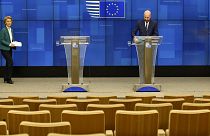 Charles Michel and Ursula von der Leyen arrive to address a nearly empty press theatre after a video-conference with G7 leaders at the European Council building in Brussels