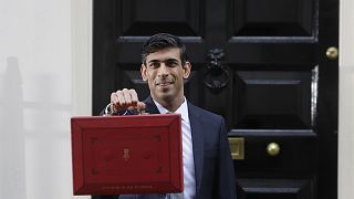 Britain's Chancellor of the Exchequer Rishi Sunak stands outside No 11 Downing Street and holds up the traditional red box that contains the budget speech for the media