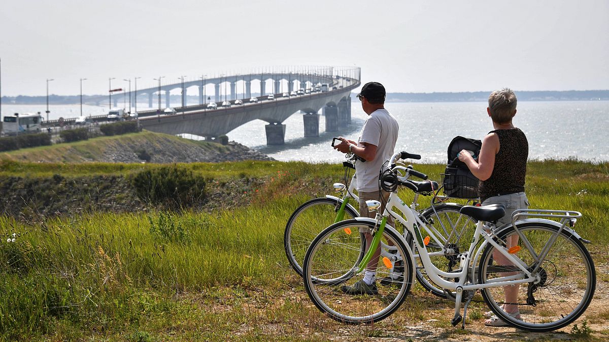 Des promeneurs à vélo admirent le pont de l'île de Ré, en Charente-Maritime - France - le 16 mai 2018