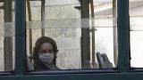 A woman wears a protective mask as she rides in a tram, in Rome, Wednesday, March 18, 2020. 