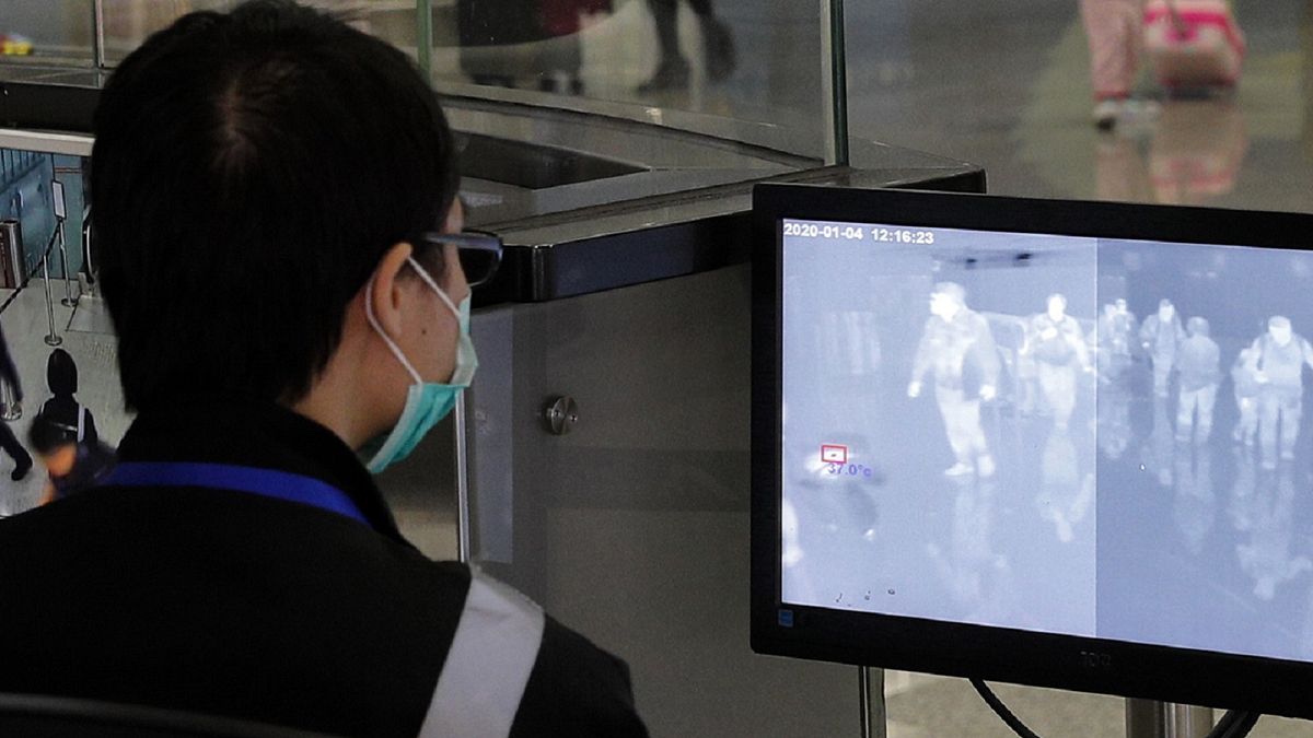 A health surveillance officer monitors passengers arriving at the Hong Kong International airport in Hong Kong