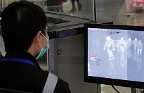 A health surveillance officer monitors passengers arriving at the Hong Kong International airport in Hong Kong