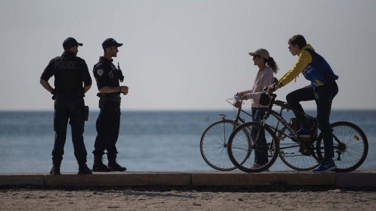 French police issue a warning to cyclists on a beach in Marseille, southern France, Thursday, March 19, 2020.