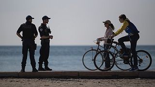 French police issue a warning to cyclists on a beach in Marseille, southern France, Thursday, March 19, 2020.