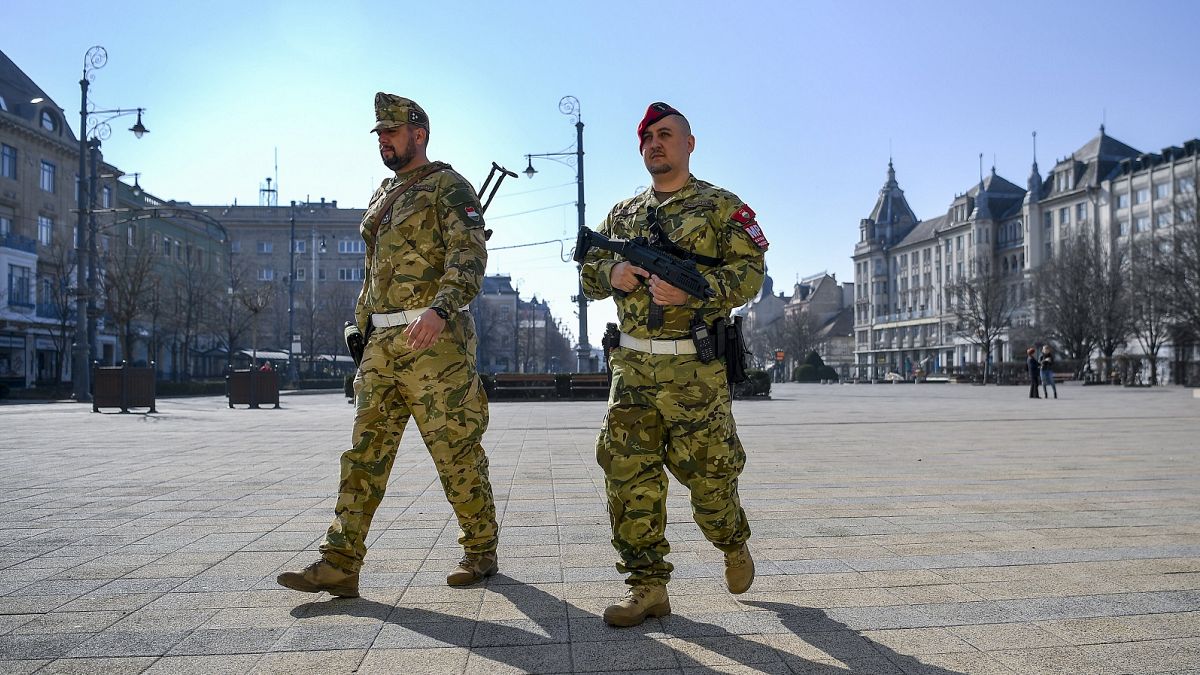 A soldier and a member of the military police walk on the main square of Debrecen, Hungary, Friday, March 20, 2020