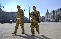 A soldier and a member of the military police walk on the main square of Debrecen, Hungary, Friday, March 20, 2020