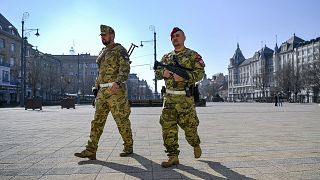 A soldier and a member of the military police walk on the main square of Debrecen, Hungary, Friday, March 20, 2020