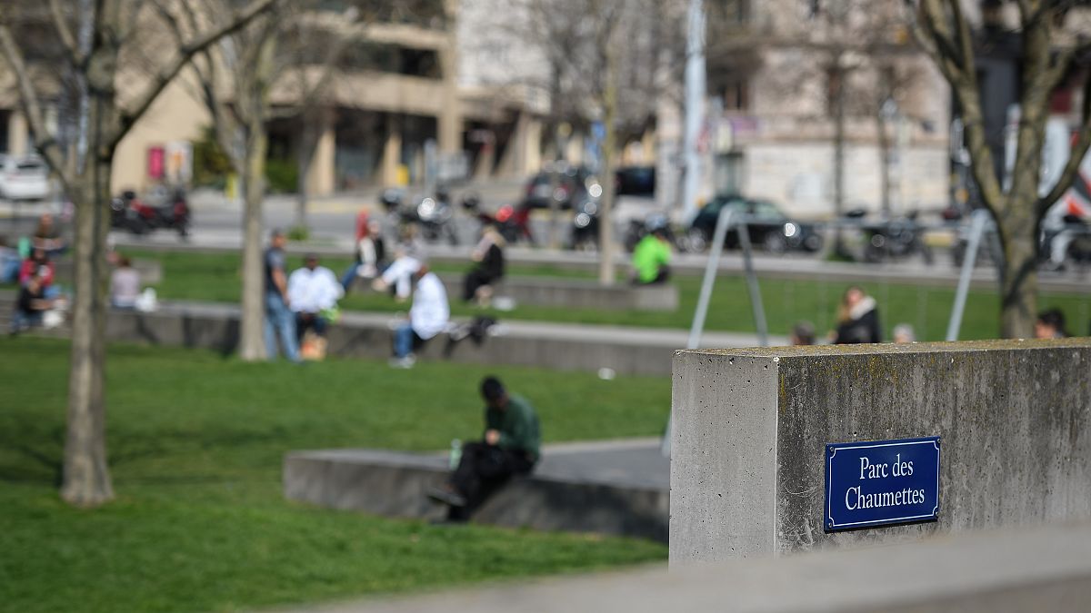 People relax in a park next to the Geneva University Hospitals (HUG)