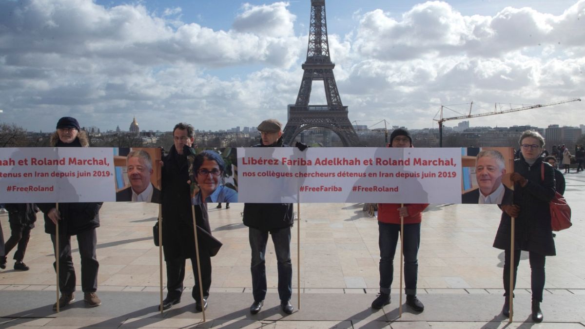 People gather with banners at Trocadero square in Paris, Tuesday, Feb. 11, 2020, calling for the release of French scientists Fariba Adelkhah et Roland Marchal.