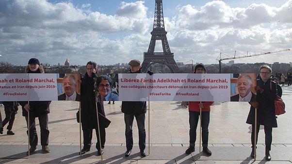 People gather with banners at Trocadero square in Paris Tuesday Feb. 11 2020 calling for the release of French scientists Fariba Adelkhah et Roland Marchal