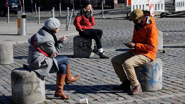People sit on the bollards on the Admiral Bridge in Berlin's Kreuzberg district on March 22, 2020, amidst the new coronavirus COVID-19 pandemic. (Photo by David GANNON / AFP) People sit on the bollards on the Admiral Bridge in Berlin's Kreuzberg district on March 22, 2020, amidst the new coronavirus COVID-19 pandemic. (Photo by David GANNON / AFP)