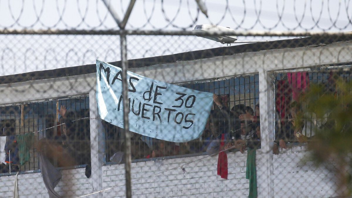 Los reclusos muestran un cartel que dice "Más de 30 muertos" en la cárcel La Modelo de Bogotá, Colombia.