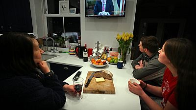 Una familia escucha el discurso televisado del primer ministro Boris Johnson