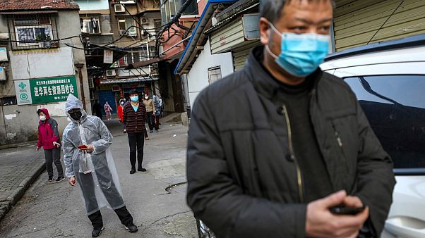 Des habitants font la queue pour acheter du porc à l'entrée de leur résidence, le 18 mars à Wuhan en Chine Des habitants font la queue pour acheter du porc à l'entrée de leur résidence, le 18 mars à Wuhan en Chine