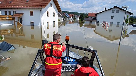 Members of the German Life-Saving Association patrol onboard a boat through the flooded streets in Deggendorf, Bavaria, 5 June 2013 