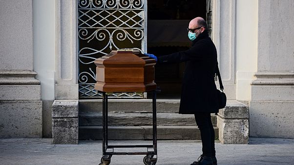 A man touches the coffin of his mother during a funeral service in the closed cemetery of Seriate, near Bergamo, Lombardy, on March 20, 2020. A man touches the coffin of his mother during a funeral service in the closed cemetery of Seriate, near Bergamo, Lombardy, on March 20, 2020.