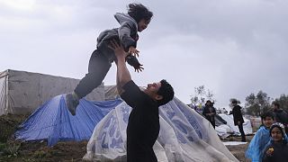 Migrants play next to their makeshift tents outside the perimeter of the overcrowded Moria refugee camp on the northeastern Aegean island of Lesbos, Greece