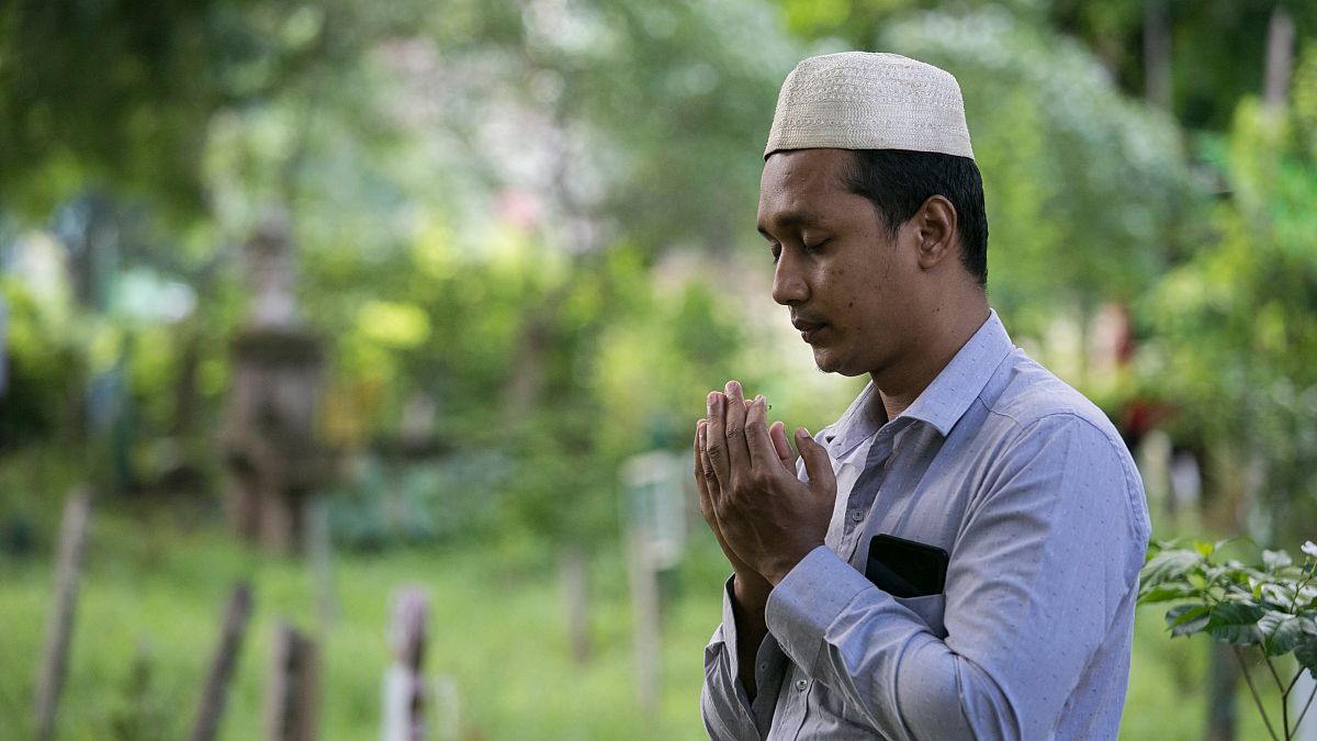 مسلم يقرأ الفاتحة على ذويه في مقبرة في يانغون في ميانمار خلال عيد الفطر. 05/06/2019