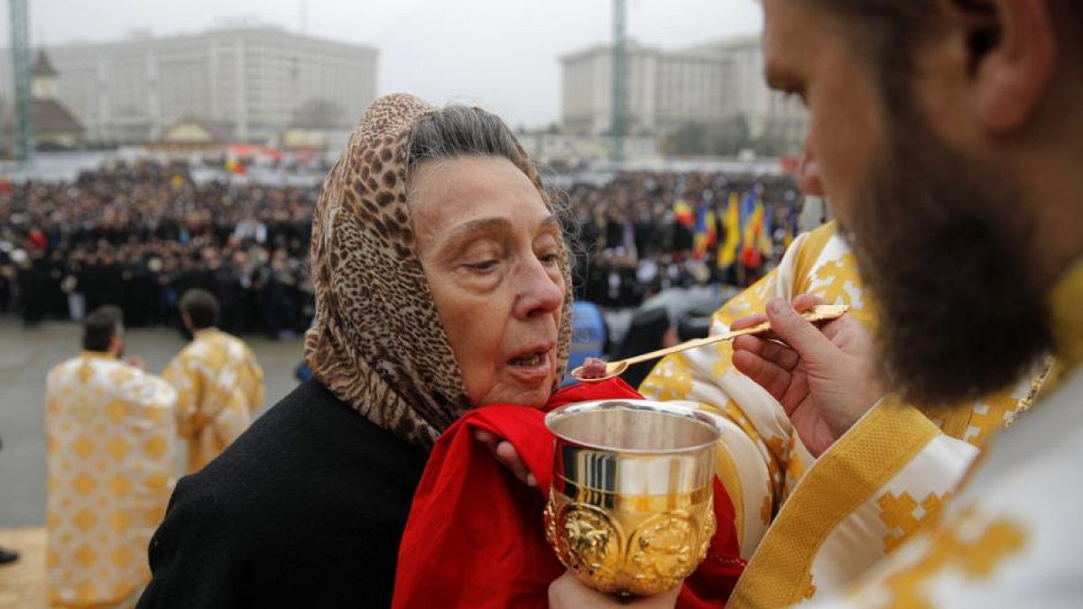 Eine Frau empfängt die Kommunion in Bukarest, 2018.