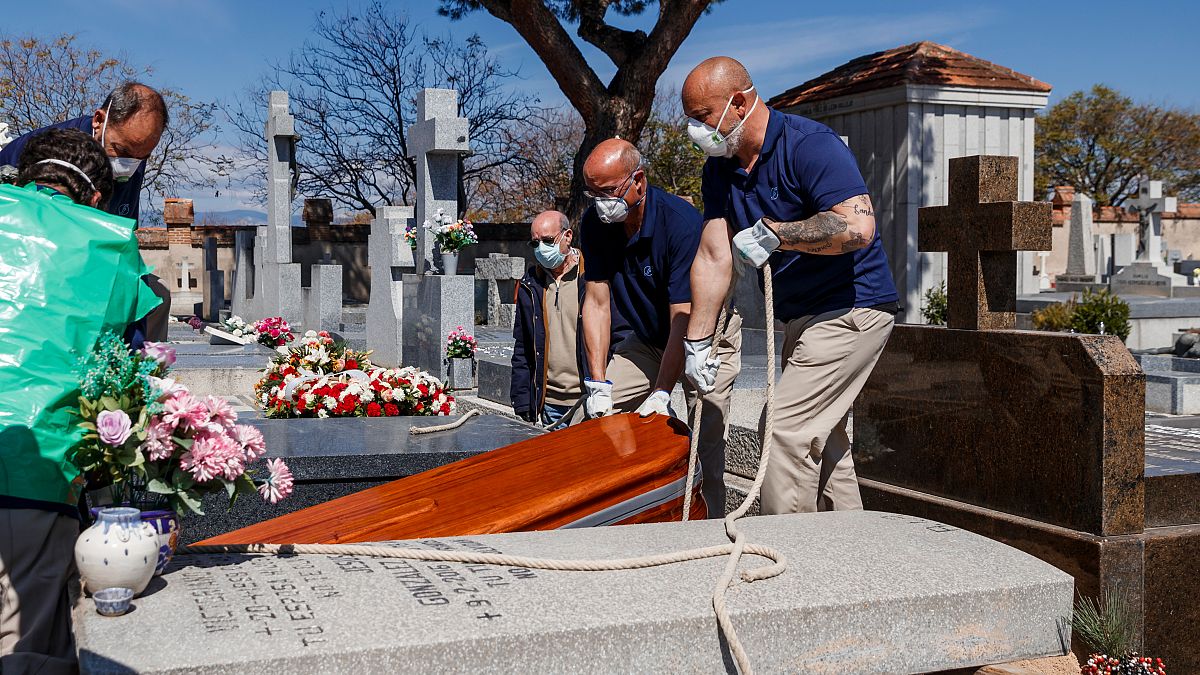 The coffin of a COVID-19 coronavirus victim is buried at Fuencarral cemetery in Madrid on March 29, 2020. 