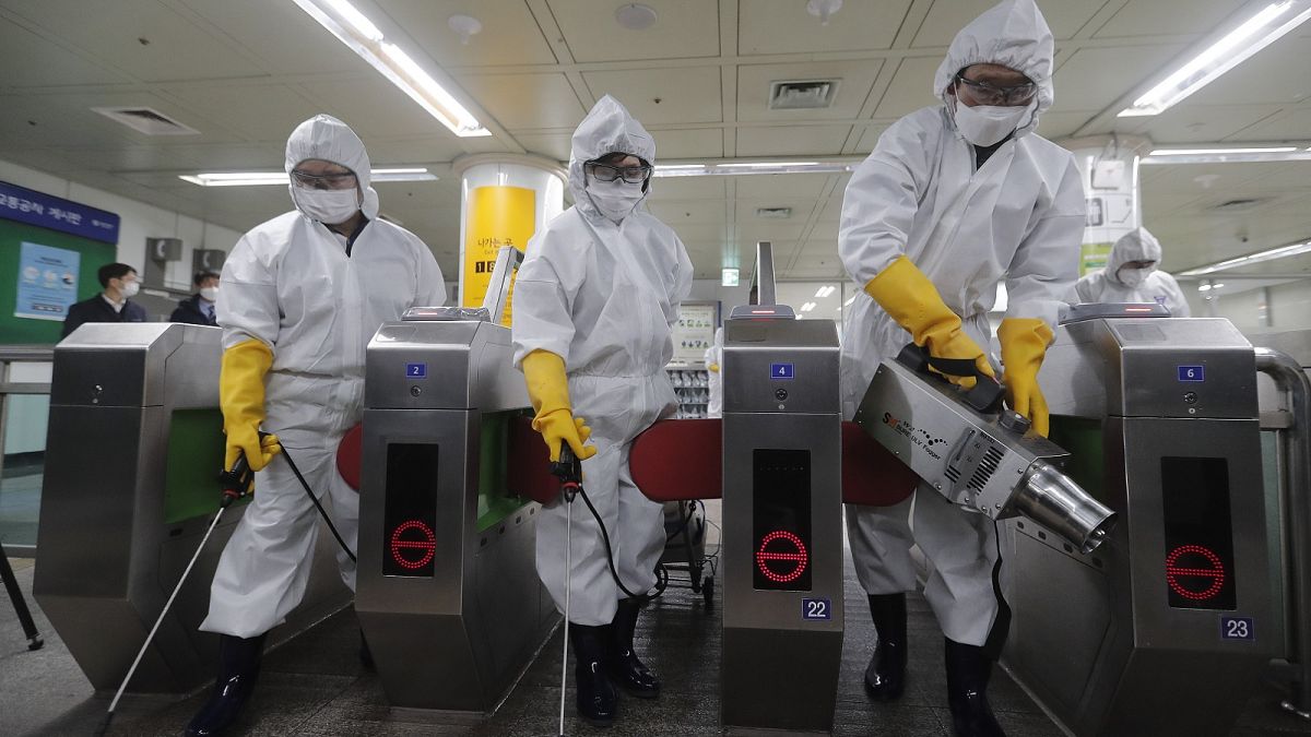 Workers wearing protective gears spray disinfectant as a precaution against the new coronavirus at a subway station in Seoul, South Korea, Friday, Feb. 28, 2020