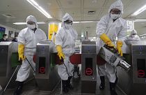 Workers wearing protective gears spray disinfectant as a precaution against the new coronavirus at a subway station in Seoul, South Korea, Friday, Feb. 28, 2020
