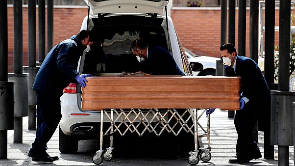 Le cercueil d'une victime du Covid-19 pris en charge par des agents funéraires, dans un cimetière de Madrid le 24 mars 2020. Le cercueil d'une victime du Covid-19 pris en charge par des agents funéraires, dans un cimetière de Madrid le 24 mars 2020.